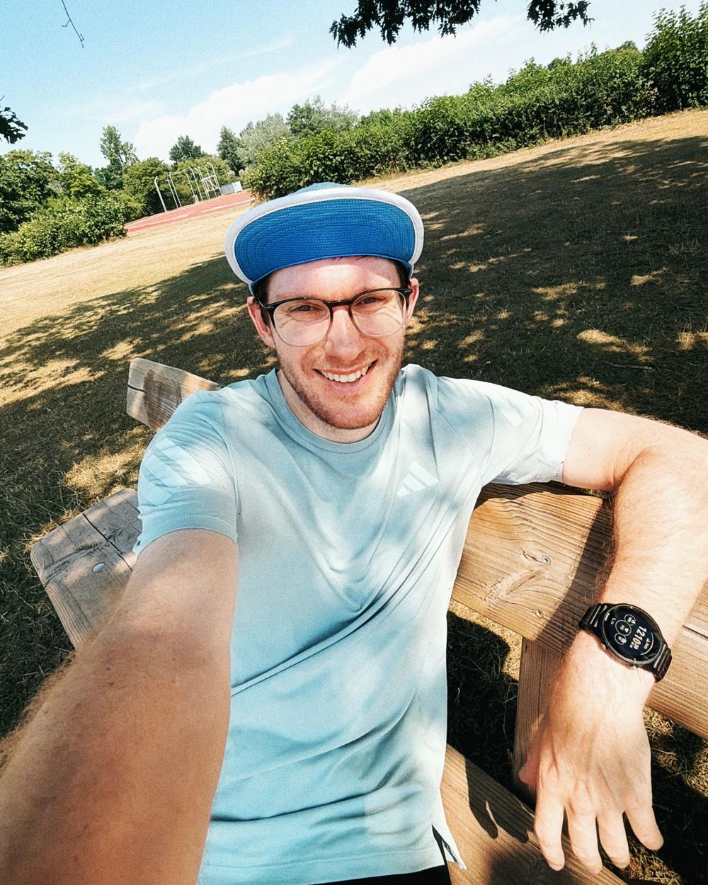 Simon auf einer Bank neben der Laufbahn